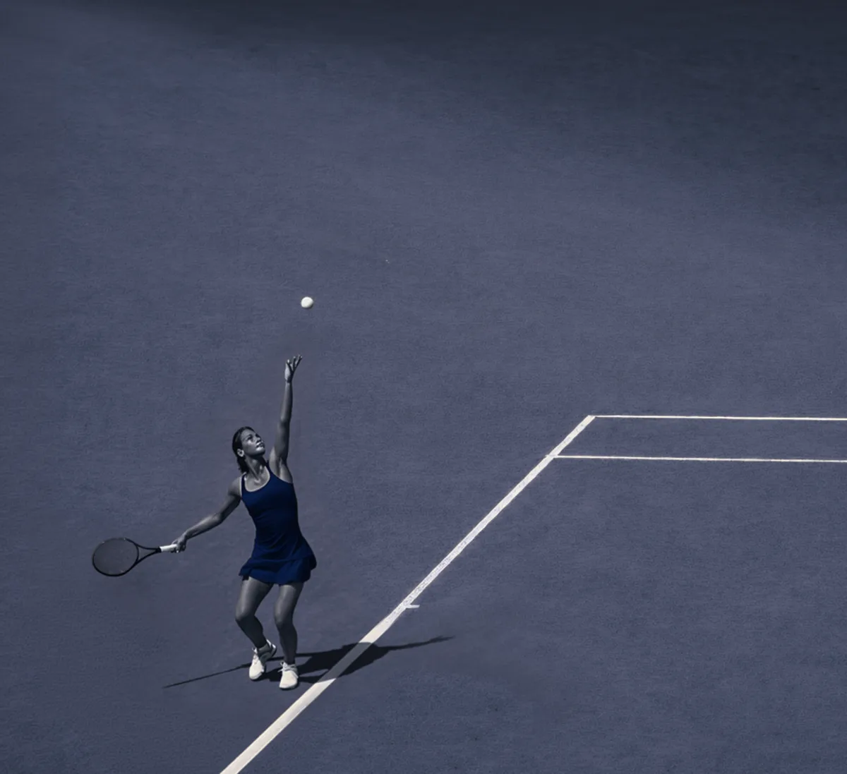 Joueuse de tennis au service sur un court bleu nuit